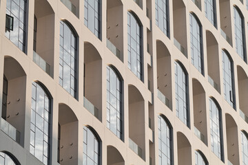 Geometric facade of repeating arched windows in contemporary apartment building © Namsun