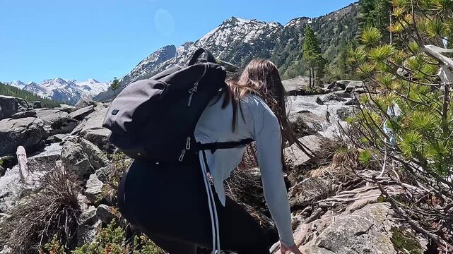Mountain travel in Russia. Altai Republic, Multinsky Lakes. First-person view, a journey to the lakes over rocks. A couple walking over rocks with backpacks.