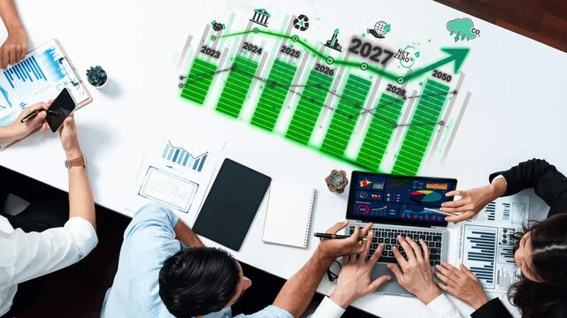 Business professionals analyzing financial data and growth projections in an office setting with charts and graphs showcasing future trends and sustainability initiatives Sigmoid