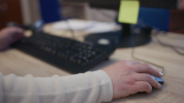 Office worker hands using a computer mouse and keyboard