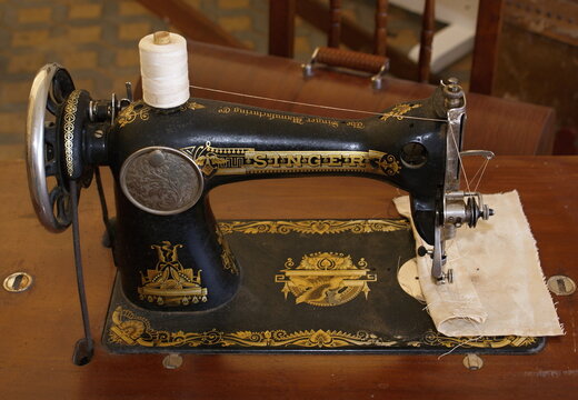 Vintage Singer sewing machine on wooden table for tailoring