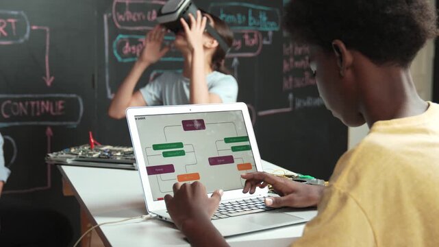 African boy programming system while caucasian girl enter metaverse while sitting at blackboard with engineering code written.high school girl wearing VR or headset in STEM technology. Edification
