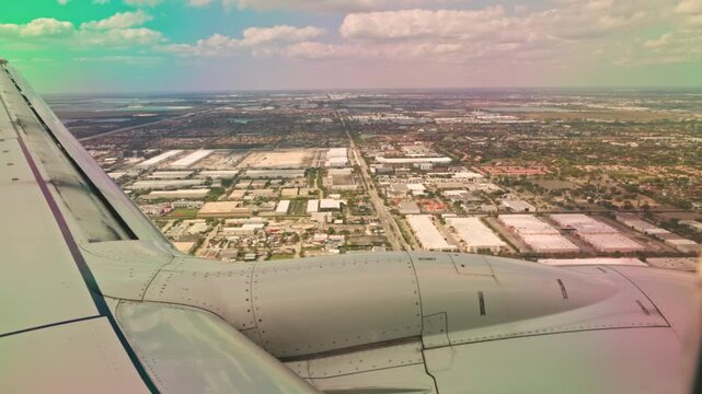 Beautiful view of airplane wing during landing over Miami cityscape with urban grid and cloudy sky. Miami. USA.