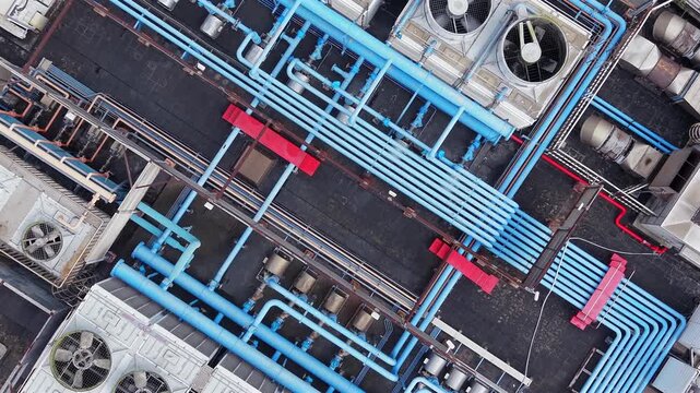 Industrial HVAC system and blue pipes on building rooftop.