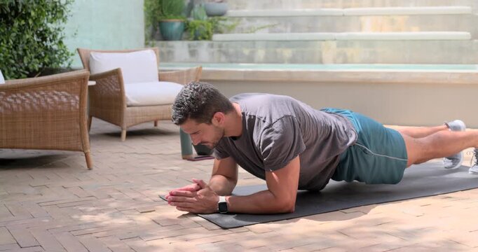Watch beep starting set, man holding forearm plank, lowering hips, dropping knees while toning core