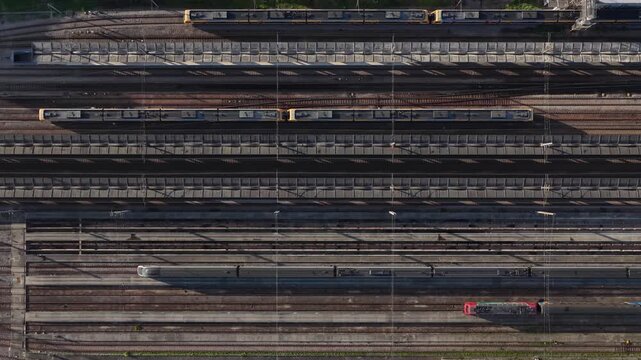 Aerial view of multiple trains sitting on parallel tracks, with the industrial textures and geometric patterns, Porto, Portugal.
