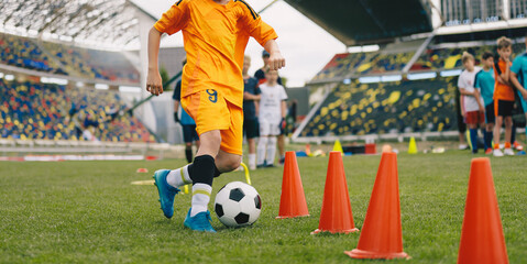 Kids Soccer Dribbling Drill. Young Player Training with Cones on Football Field; Youth Skill Development, Speed and Ball Control Practice