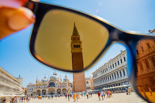 Venice, Italy - 29 March 2026: View of St. Mark's Square framed through sunglasses, where the Campanile di San Marco reflects in the lenses against the vibrant blue sky.