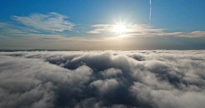
Scenic aerial view above clouds sunset. Radiant sun rays horizon blue sky background. Heavenly atmosphere white fluffy clouds golden hour sunlight. Professional nature stock footage asset.
