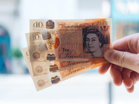 London, United Kingdom - 20 June 2025: View of crisp ten pound notes held aloft, their vibrant hues contrasting against a soft, blurred backdrop.
