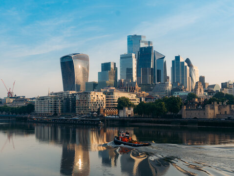 London, United Kingdom - 20 June 2025: View of the modern skyline reflecting in the Thames, with iconic buildings like the Walkie Talkie shimmering under a soft, warm light.