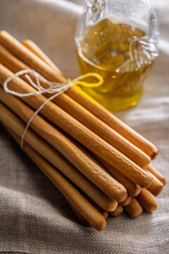 Rustic Grissini Breadsticks Bundle Tied With String on Linen Cloth, Closeup Food Still Life