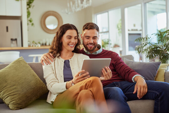 Couple using digital tablet at home