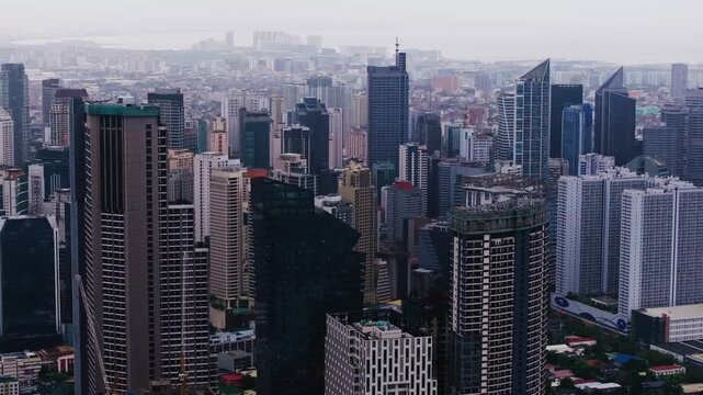 Sideways drone shot of Makati skyline in Metro Manila Philippines with hazy mood