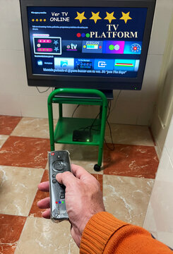 Mando de televisi&oacute;n para cambiar de canal y plataforma digital TV con pantalla pulsando bot&oacute;n para zapping de programa, pel&iacute;cula y serie