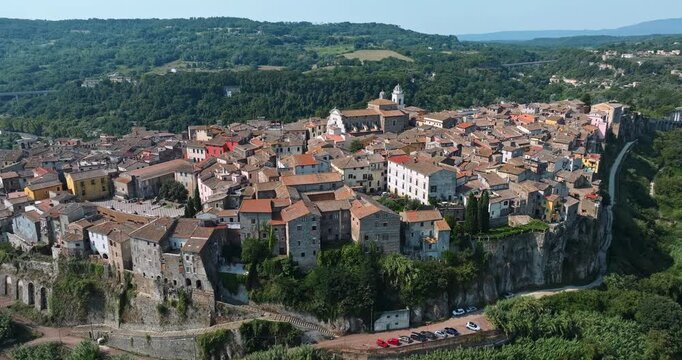 Medieval hilltop town Orte Italy drone aerial panorama. Historic stone buildings cliff edge green nature valley summer sunlight ancient italian architecture travel wanderlust concept stock imagery.