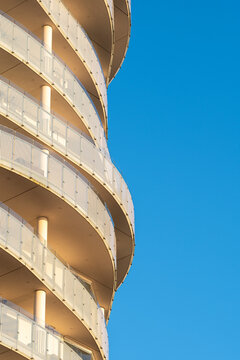Minimal architecture of residential building features balconies facade curvature and repetition beneath open sky for calm modern geometric composition