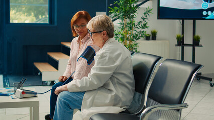 Doctor and asian woman using tonometer to measure hypertension, checking high or low blood pressure...
