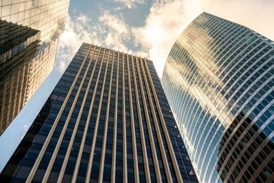 Looking up to skyline skyscraper architecture in Paris La Defense under clouds suggesting corporate office finance business momentum in the district