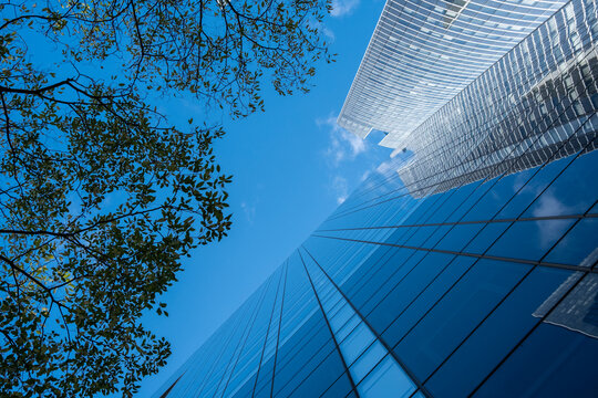 Looking up at glass facade skyscraper architecture in Paris La Defense capturing corporate office finance business ambition within a modern district skyline