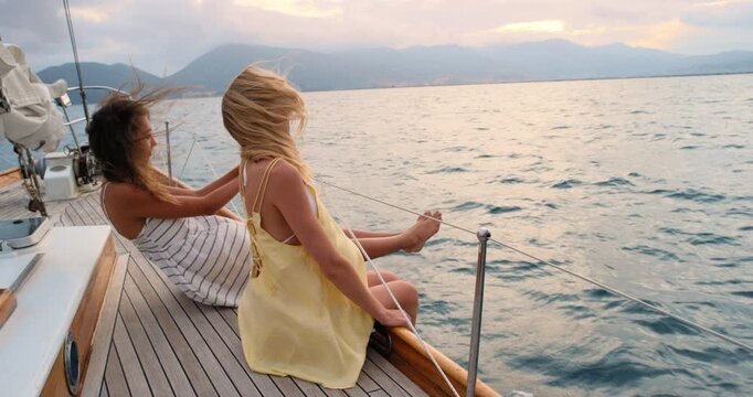 Travel, sunset and friends on yacht in ocean for vacation, tropical adventure and tourist destination. Relax, nature and women on boat for cruise, journey and explore islands on summer holiday