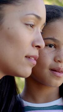 Vertical video: Leaning mom saying to daughter in yard, she making faces in striped shirt and hoops