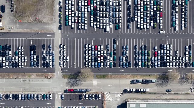 Aerial view of rows of parked cars, in a geometric array, with contrasting colors creating a visually striking pattern, Sausheim, Grand Est, France.