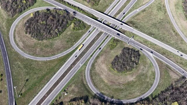 Aerial view of the winding highway interchange with multiple roads and cloverleaf ramps cutting through green fields, Sausheim, Grand Est, France.