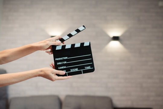 Hands holding clapperboard, signaling start of film production, cinematic movie making storytelling, industry concept