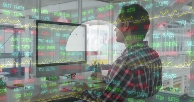 A happy young caucasian male business creative is working in a modern office and using a computer