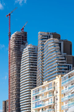 Construction of modern Benidorm Spain highrise tower with crane and skyline backdrop reflects urban growth and changing residential market