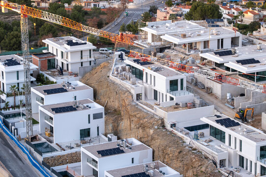 Modern housing development construction in Benidorm Spain with aerial view of crane at site capturing steady progress of new neighborhood