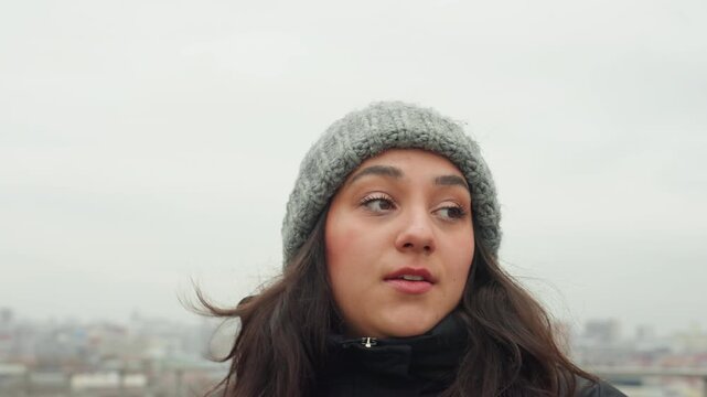 Woman dancing thoughtfully. Elegant female performing dance with windblown hair and thoughtful expression. Reflected woman engaging in dance with windswept hair beside railing showing introspection