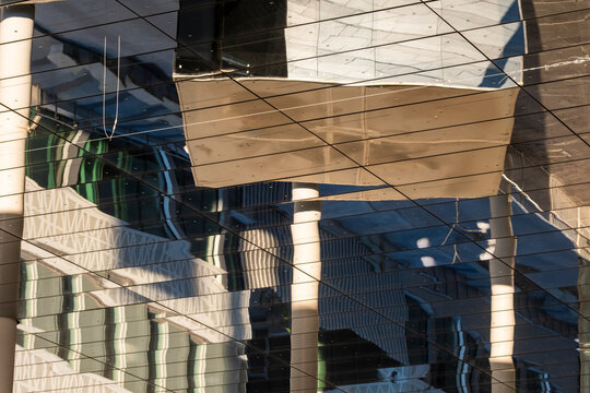 Abstract urban architecture facade where glass reflection and columns create modern pattern on the building exterior with crisp detail