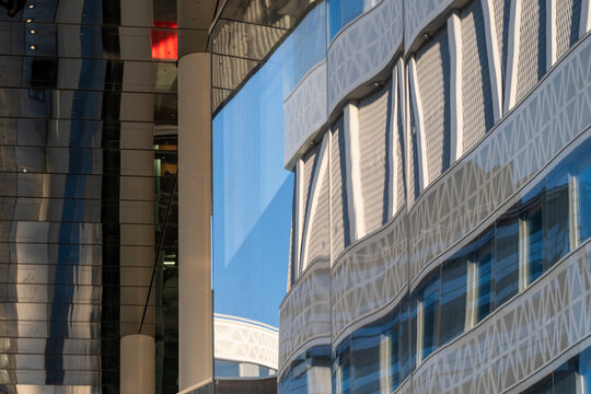 Abstract modern facade where glass curves shape architecture pattern on an urban building exterior creating sleek contemporary detail