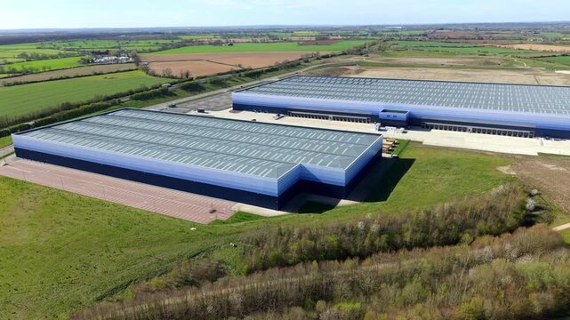 Aerial drone view of massive warehouses with blue ombre cladding at Magna Park Lutterworth UK
