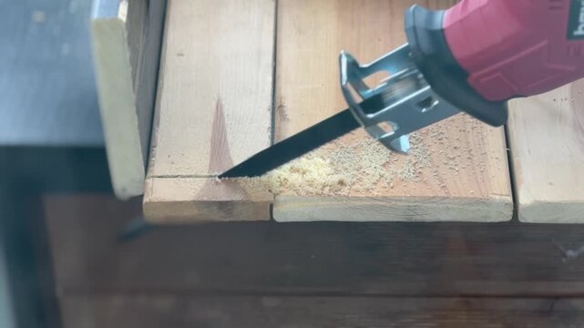 The video shows the process of creating a precise groove or chamfer on a wooden workpiece using a DIY cutting tool.