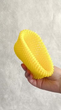 Yellow foam net for fruit in hand. Packaging for transportation, delivery of vegetables