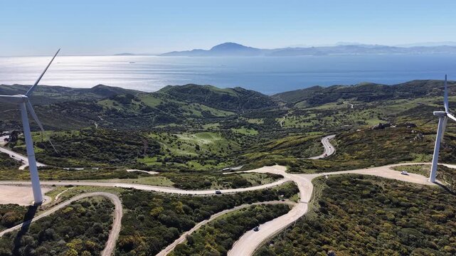 Aerial panorama of wind turbines on the hills of Andalusia, looking south towards the Strait of Gibraltar and the Moroccan mountains.