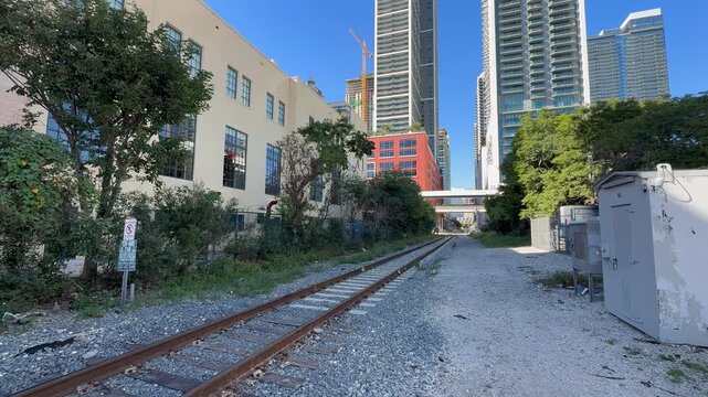 Florida East Coast Railway tracks in Downtown Miami next to the Freedom tower. This line goes to Port Miami. People and cars are crossing tracks. Miami, Florida 