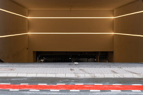 Minimal architecture in empty concrete tunnel with interior lights and street lines showing symmetry and depth for abstract urban passage background
