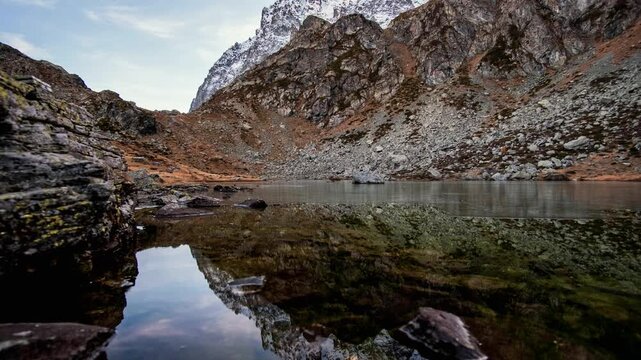 Zoom out scenic view of Fiorenza Lake with mountains reflection in Monviso Park Alps Italy.