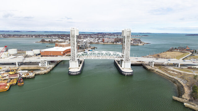Aerial view of the bright white Fore River Bridge cutting through the emerald waters under a cloudy sky, Quincy, Massachusetts, United States.