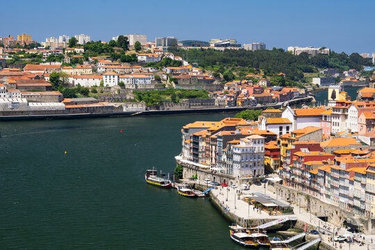 Aerial view of terracotta rooftops cascade down to the riverfront, reflecting the warm Portuguese sun, Porto, Porto District, Portugal.