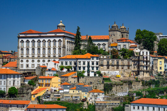Aerial view of Dom Luis I Bridge and the historic Ribeira district cascade in warm terracotta tones under the bright Portuguese sun, Porto, Porto District, Portugal.