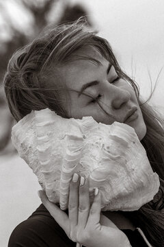 Giant Seashell by Woman&rsquo;s Face on Beach, Black and White Artistic Portrait
