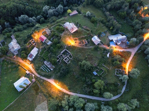Aerial view of rustic buildings nestled among lush greenery, illuminated by warm, golden light, creating a serene and inviting atmosphere, Posof, Ardahan, Turkey.