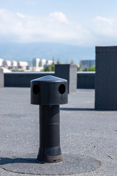 Vertical shot of a plastic roof aerator for moisture removal on a flat roofing system with bitumen waterproofing.