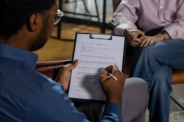Man writing on form during session