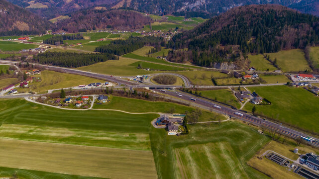 Aerial view of the valley's patchwork fields and winding roads contrast against the backdrop of the majestic mountains, Windischgarsten, Upper Austria, Austria.